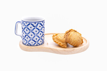  curry puff and coffee mug on wooden plate close up