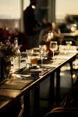 Festive table setting. Server table flooded with golden sunset sunlight.Wedding day event organization table setting decor. luxury event.
