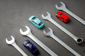 wrenches and toy cars on a gray surface