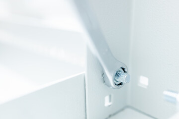 close-up of a wrench tightening a nut on a metal rack