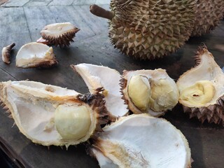 Topview of ripe durian, wood cutting board durian rind on table.