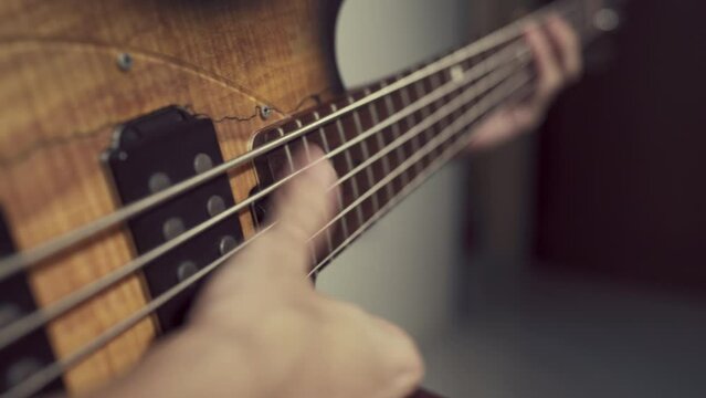 person slapping electric bass guitar