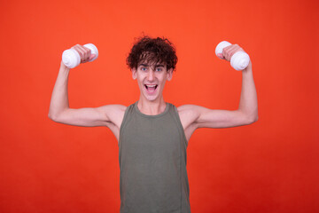 Fitness and healthy lifestyle. Funny curly guy posing on an orange background.