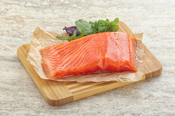 Raw salmon fillet over board
