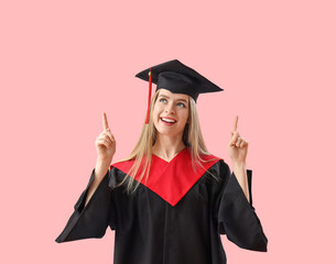 Female graduate student pointing at something on pink background