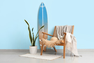 Fototapeta na wymiar Interior of living room with surfboard and plaid on armchair