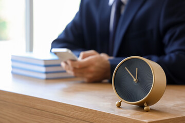 Alarm clock on table of businessman in office, closeup