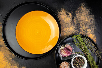 Empty orange plate with spices, menu mockup, top view.