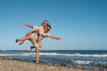 boyfriend and girlfriend husband and wife on vacation at sea have fun hugging and laughing on the beach near the sea