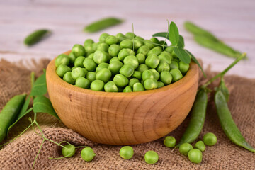 Green peas in a wooden bowl.Close-up.
