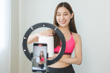 Vlogger asian young woman blogger, influencer showing product of health care, using smart mobile phone live selling food replacement, weight lose. Show goods to customer, present, streaming online.