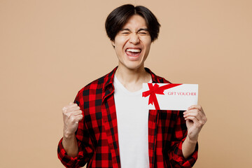 Young man of Asian ethnicity he wear red shirt casual clothes hold gift certificate coupon voucher...