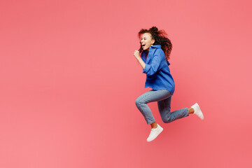 Fototapeta na wymiar Full body side profile view young woman of African American ethnicity she wear blue shirt casual clothes jump high run fast hurry up isolated on plain pastel pink background studio. Lifestyle concept.