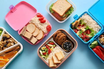 Many lunchboxes with different delicious food on blue background