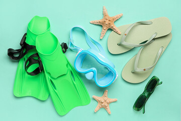 Swimming mask, flip flops, sunglasses, flippers and starfish on turquoise background © Pixel-Shot