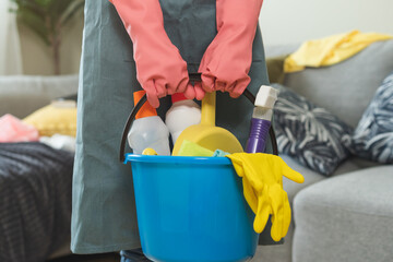 Tired household clean up, housekeeper asian young woman, girl in apron, hand holding bucket of...