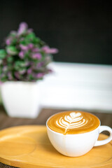 coffee pattern in a white cup on a wooden tray