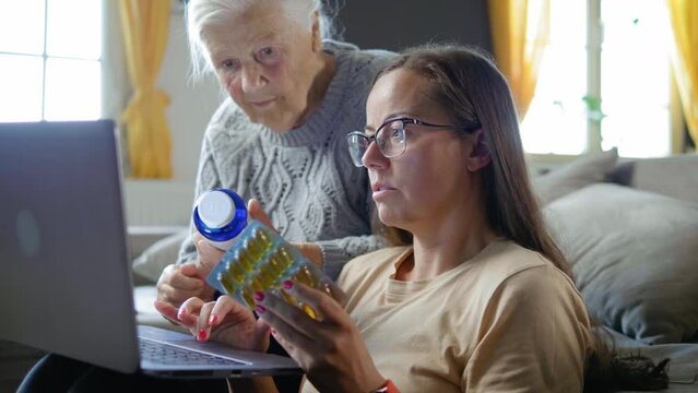 Sequence of shots of old grandmother and granddaughter ordering or searching online information about medicines using a laptop at home