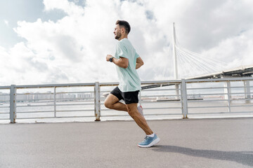 A runner trainer in full-length fitness clothes, running shoes and a fitness watch. Motivation a...