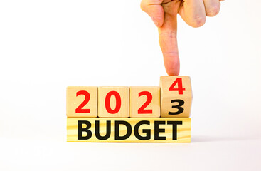 Planning 2024 budget new year symbol. Businessman turns a wooden cube and changes words Budget 2023...