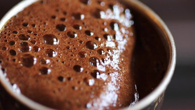 Coffee brewed in cezve on a gas stove