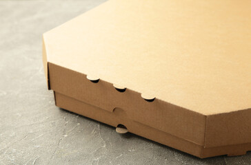 Brown pizza box on grey background. Top view