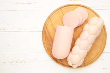 Boiled pork sausage on cutting board on white background. Space for text