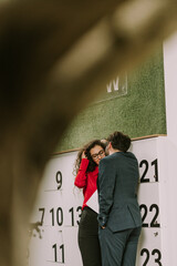 Fototapeta na wymiar A male business person kissing his girlfriend on a cheek