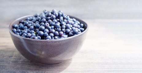 Blueberries close-up in a ceramic bowl close-up on the table, soft selective focus. Blueberry harvest, seasonal wild berries