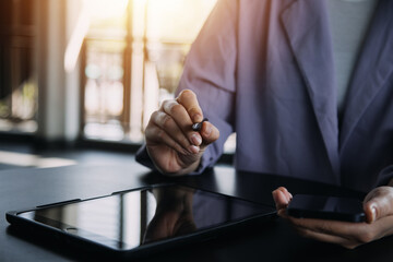 Asian Business woman using calculator and laptop for doing math finance on an office desk, tax, report, accounting, statistics, and analytical research concept