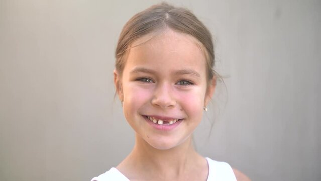 portrait of a smiling girl whose milk tooth fell out