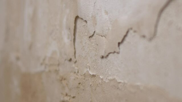 The wall, which is moistened by water and cracked paint, rotten wall surface due to moisture,