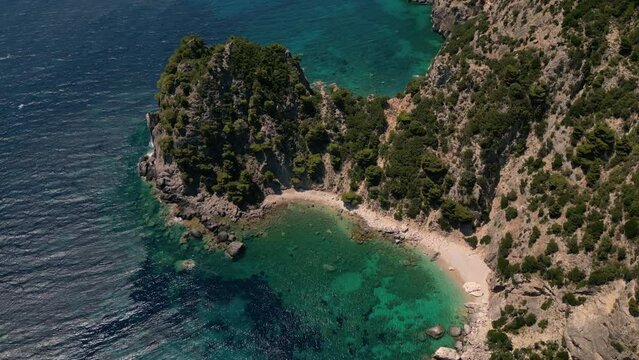 Drone footage of boats gently swaying in the sunny sea, moored not far from the Paralia Ermones Beach, on a hot day