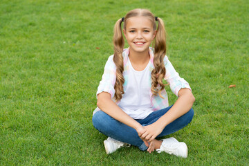 happy childhood of teen girl. summer relax in park. teen girl sitting outdoor. childhood lifestyle of teen. relax on summer lawn. girl relax peacefully on the grass. copy space banner