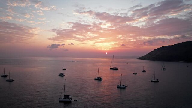 Drone sunset view at Nai Harn beach at Phuket, Thailand.
Red beautiful sky with clouds at Andaman sea. DJI Mavic cinematic aerial footage.