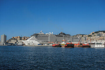 Big modern MSC Cruises cruiseship or cruise ship liner Seaside Seaview in port with downtown Genova Genoa skyline in background waiting for passengers for Mediterranean cruising holiday