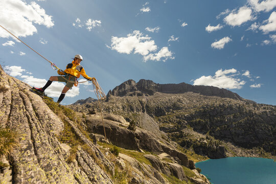 Woman climbing high mountains with blue cuelo lake with clouds, hiking having fun