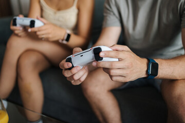 Middle selection of couple using video game joysticks gamepad and playing