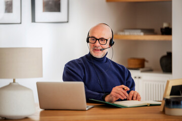 Male customer service assistant business man wearing headset and using laptop for work