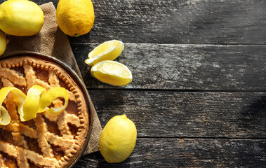 Delicious lemon pie, tart  with cooking ingredients on the wooden table
