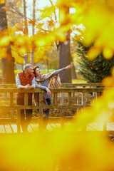 smiling romantic couple in park on bridge