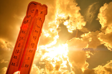 Melting street thermometer against bright summer sun.High temperature.Summer heat.Concept of global...
