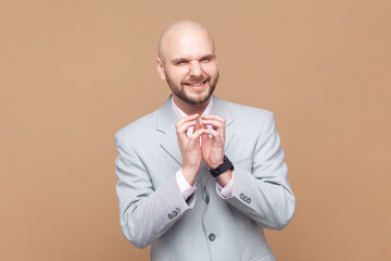 Portrait of sly smiling bald bearded man looking at camera with cunning facial expression, planning...