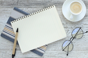 Open Notebook With Blank Pages, Pen And Cup Of Coffee On Wooden Table. Top View