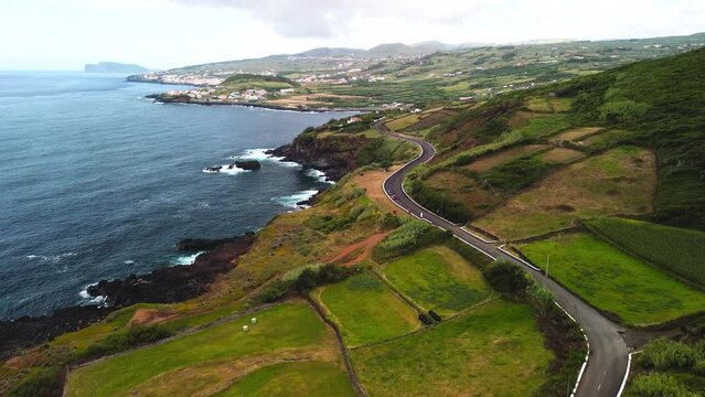 Estrada na linha de costa da Ilha Terceira nos A&ccedil;ores. Ao fundo o Monte Brasil. 