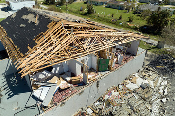 Hurricane Ian destroyed house roof and walls in Florida residential area. Natural disaster and its consequences