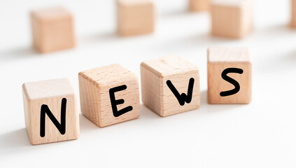 four wooden blocks with text News on table. copy space. white background