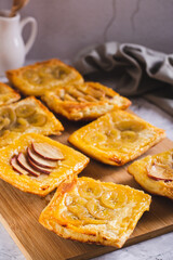 Small upside-down puff pastry tarts with apple and banana on the board vertical view