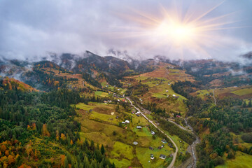 Flight over fog in Ukrainian Carpathians in summer. A thick layer of fog covers the mountains with a continuous carpet. Aerial drone view.