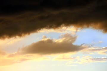 Fototapeta na wymiar Bewölkter Himmel bei Sonnenuntergang. Der Himmel ist durch eine Lücke in den Wolken sichtbar. Das Bild vermittelt eine Stimmung von einem bevorstehenden Sturm oder schlechtem Wetter.